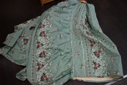 A mint green vintage padded bed throw having rose and floral pattern.