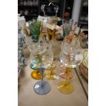 An assortment of coloured glasses including etched wine glasses.