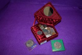 A small red jewellery case containing a small selection of British coins