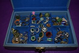 A jewellery box containing a large selection of costume jewellery rings of various designs