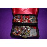 A small black jewellery box containing a selection of earrings etc
