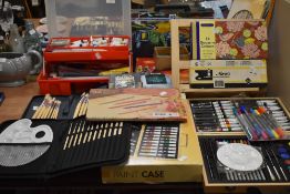 A large collection of paint, paintbrushes and similar art supplies.
