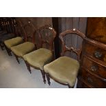 A set of four Victorian dining chairs having Gothic style rail backs and classical style legs