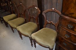 A set of four Victorian dining chairs having Gothic style rail backs and classical style legs