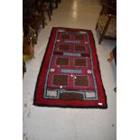 A traditional wool rug in shades of burgundy brown and sky blue , approx. 150 x 72cm