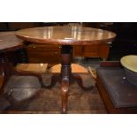 A 19th Century oak pedestal table, cut down height, having circular top over turned column and