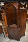 A reproduction mahogany effect corner wall shelf having cupboard under, , in the Regency style