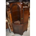 A reproduction mahogany effect corner wall shelf having cupboard under, , in the Regency style