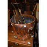 A copper and brass coal bucket, traditional bellows and a selection of fire tools