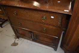 An early 20th Century oak bedroom cabinet having two drawers and double cupboard under