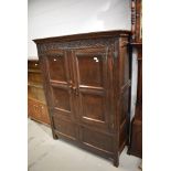 A period oak cabinet of panel form having double doors, carved frieze with monogram TB and '1678'