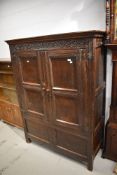 A period oak cabinet of panel form having double doors, carved frieze with monogram TB and '1678'