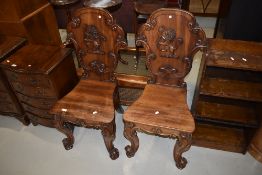 A gorgeous pair of 19th Century mahogany hall chairs having Armorial style rampant lion applique