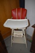 A vintage Childs folding high/low chair , wooden frame and vinyl seat