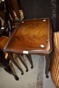 A traditional nest of three reproduction tables having cabriole legs and glass tops