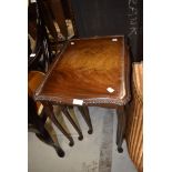 A traditional nest of three reproduction tables having cabriole legs and glass tops