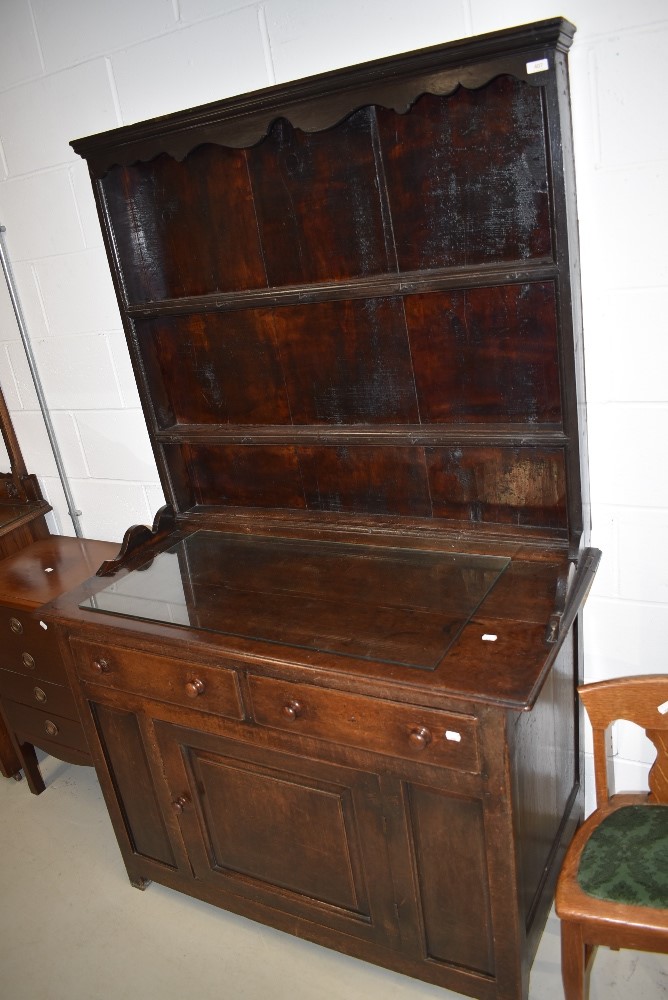 A traidtional period oak dresser, having delft back over double drawer base and single panel