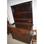 A traidtional period oak dresser, having delft back over double drawer base and single panel