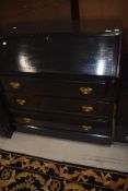 A dark stained bureau in the traditional form with reproduction Georgian style brass handles