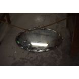 A vintage frameless oval wall mirror