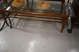 A 1970s glass top coffee table of stylised form, approx. 114 x 48cm