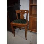 An interesting late 19th or early 20th Century golden oak stool having vase back and later