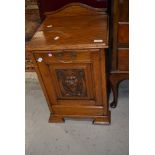 A Victorian golden oak coal purdonium having carved mask decoration to front panel