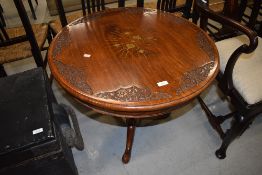 A brass inlaid Indian or similar table having extensive floral carving to top