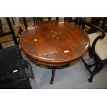 A brass inlaid Indian or similar table having extensive floral carving to top