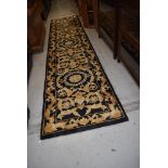 A black and gold carpet runner, approx. 370 x 77cm, nice condition with very little if any use