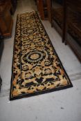 A black and gold carpet runner, approx. 370 x 77cm, nice condition with very little if any use