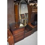 A mid century dark wood veneered dressing table having oval mirror and four drawers