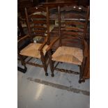 A pair of traditional rush seated ladder back carver chairs