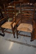 A pair of traditional rush seated ladder back carver chairs