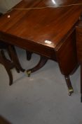 A 19th Century mahogany Pembroke Regency style table on turned splay legs with brass feet and