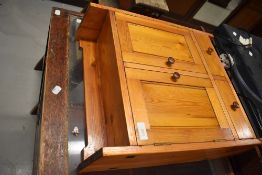 A stained pine bathroom cabinet