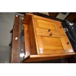 A stained pine bathroom cabinet