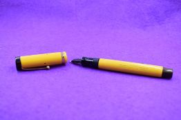 A Parker Duofold Lucky Curve button fill fountain pen in Mandarin yellow with single band to cap,