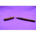 A Watermans Ideal Eyedropper fountain pen in red and black mottled hard rubber, clipless, with