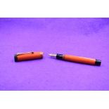 A Parker Duofold Lucky Curve Jr button fill fountain pen in orange with a single band to cap and