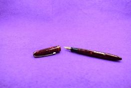 A Mabie Todd & Co Blackbird Self filler Leverfill fountain pen, in red marble, with a single band to
