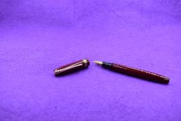 A Mabie Todd & Co Swan Leverless twist filler, in maroon with two narrow and one broad band to cap