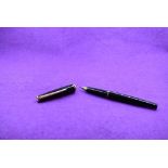 A Montblanc cartridge fountain pen in black with single narrow band to cap and band to rim of cap,