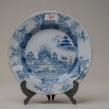 An English blue and white wear delft plate decorated in a Chinese style pattern depicting fantasy