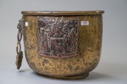An antique brass worked fire basket or similar with a cooper coat of arms or family crest motif also