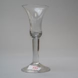 A plain stem mid 18th century wine glass with bell bowl and tear to base of bowl on folded foot