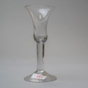 A plain stem mid 18th century wine glass with bell bowl and tear to base of bowl on folded foot