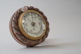 A vintage wall mounted oak barometer having carved rope like detail to edging.