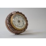 A vintage wall mounted oak barometer having carved rope like detail to edging.