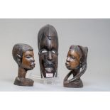 A pair of African tribal heads carved in heavy ethnic woods and a carved wall mounted mask.
